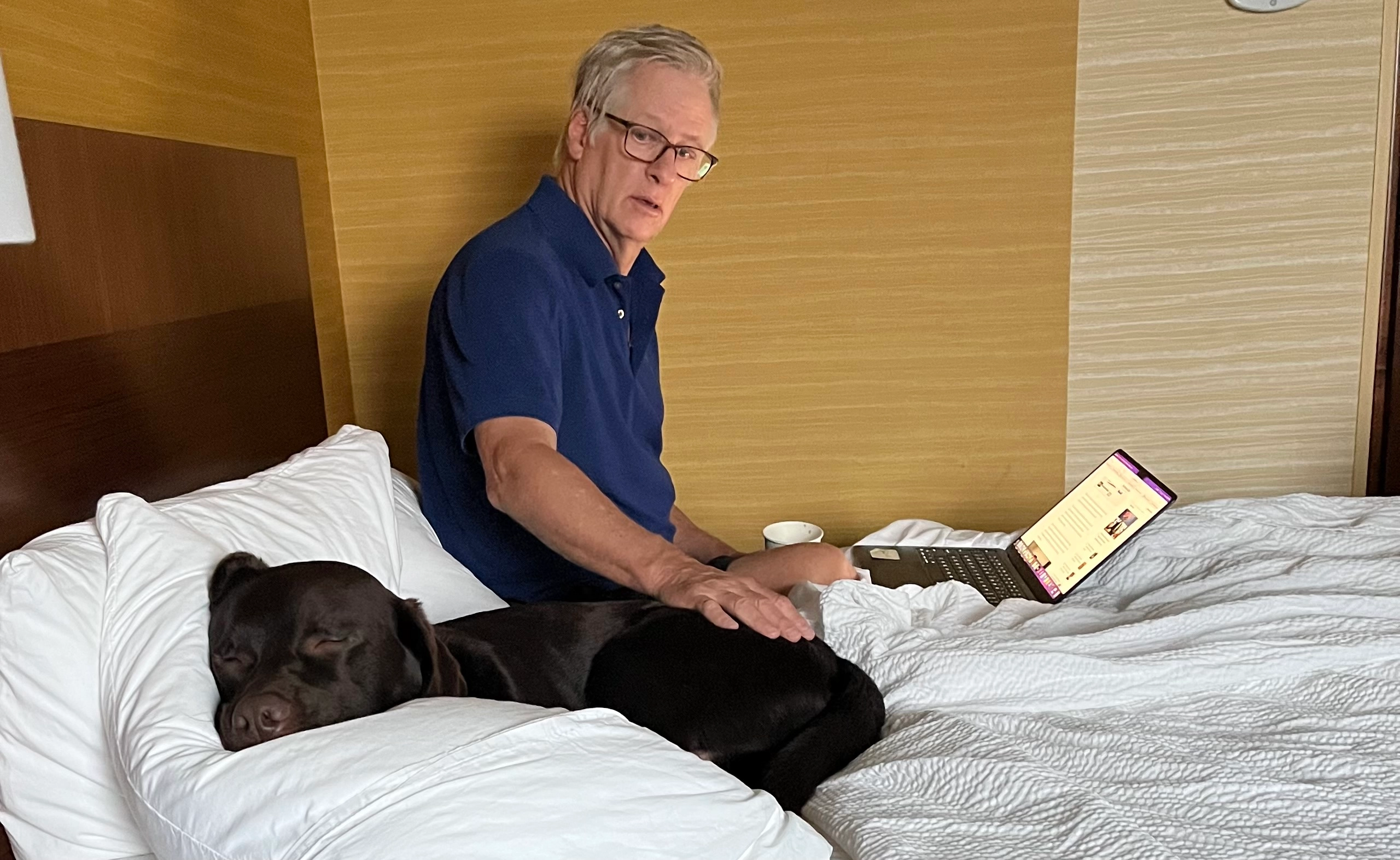 Dad and Scooby on a hotel bed.